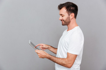 Portrait of a smiling casual man holding tablet computer