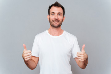 Man showing two thumbs up and looking at camera
