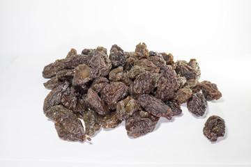 An isolated pile of sun dried plums on white background 