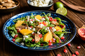 Arugula salad with pomegranate, chicken meat, persimmons and Feta cheese