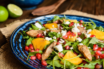 Arugula salad with pomegranate, chicken meat, persimmons and Feta cheese