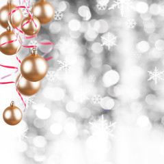 golden Christmas ornaments on a silver background with flakes