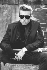 Young handsome blond haired hooligan portrait with baseball bat