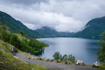 Gravel road at norwegian beautiful fjord shore.