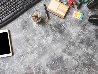 Top view of Keybroad with tablet,headphone,notebook,cactus and Office supplies on Grunge  gray background