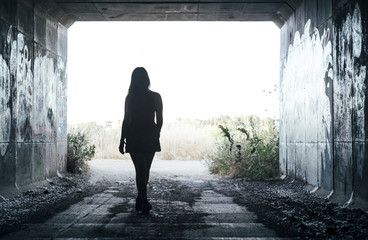 Chica joven caminando a través de un túnel