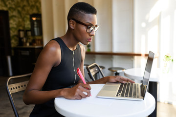 Young african business woman working at the cafe
