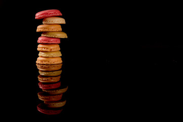 Sweet and colorful french macaroon or macaron on black background