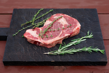 Raw rib-eye steak on cutting board