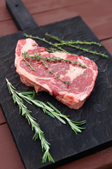 Raw rib-eye steak on cutting board