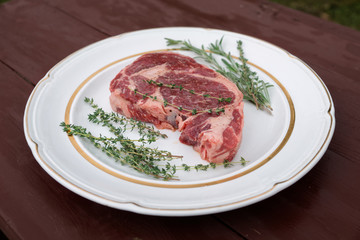 Rib eye steak in a rustic plate on wooden table