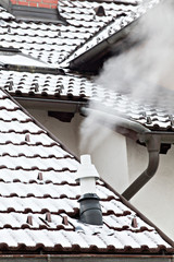 Rauchender Kamin im Winter