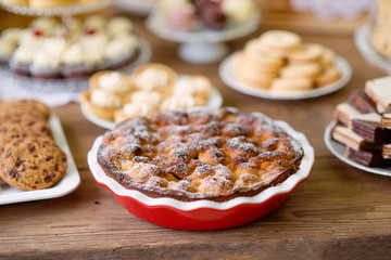 Table with sweet pie, tarts and cookies, wooden background.