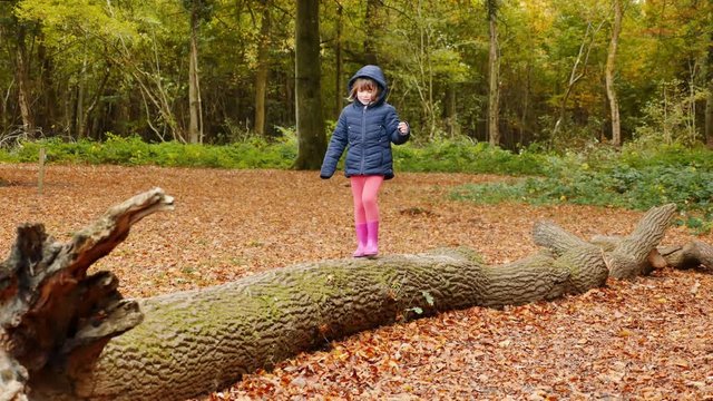 jeune fille en &eacute;quilibre sur un tronc (4k)