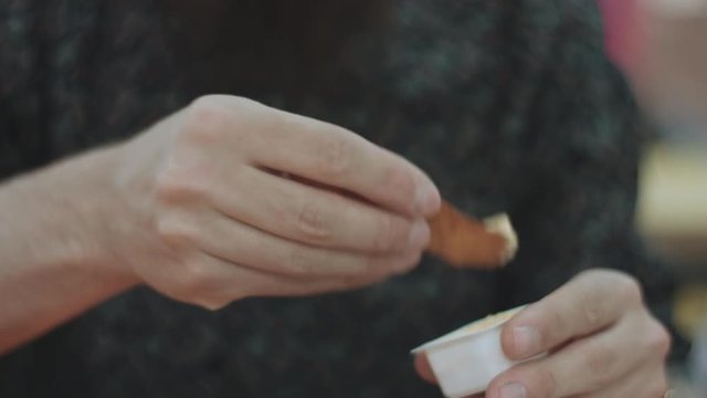 Bearded guy eats potatoes with cheese sauce, closeup shot
