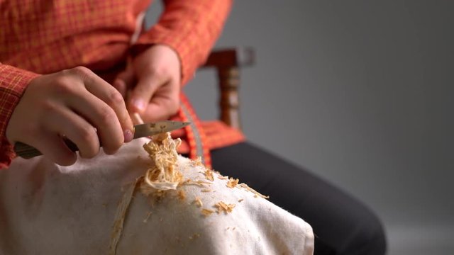 Wickerwork. View of boy cleans rod from bark