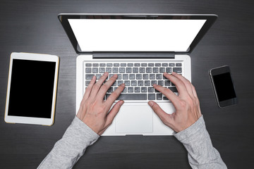 Fototapeta premium Top view of Male hands working on Laptop on the desk.