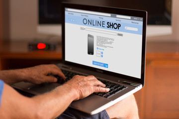 Fototapeta na wymiar Cropped image of a senior man using his laptop at home and shopp