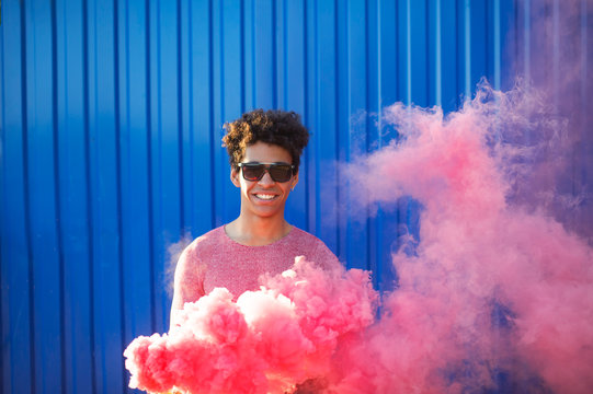 Black young man holding a smoke grenade