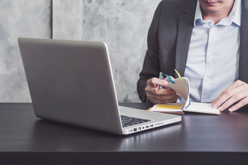 Close up of Businessman reading notebook on the desk.