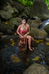 Beautiful girl with Thai dressing was playing water in the river.