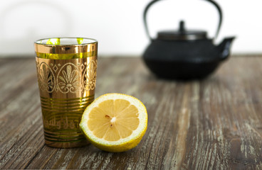 Obraz na płótnie Canvas infusión de té, vaso, tetera y limón, sobre mesa de madera
