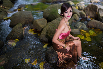 Beautiful girl with Thai dressing was playing water in the river.