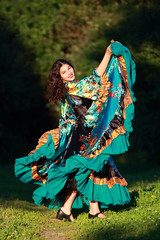 Beautiful gypsy girl in a traditional dance in the woods