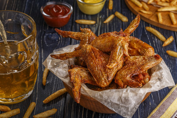 Buffalo wings with french fries and beer.