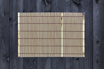 Bamboo mat on wooden table, top view