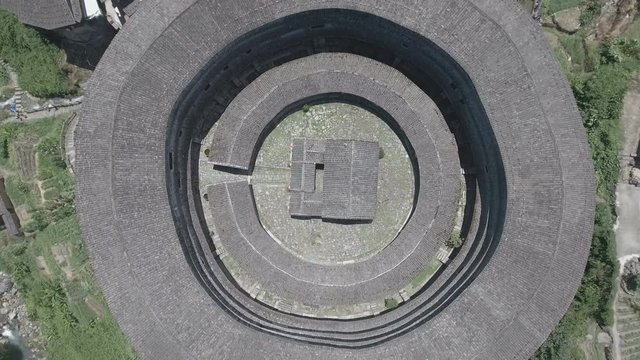 Rising up from a courtyard of a tulou round house in China