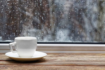 White cup on wooden windowsill - obrazy, fototapety, plakaty