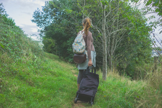 Woman with luggage in the country