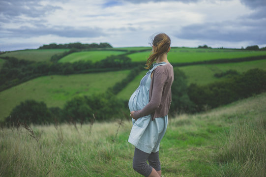 Young pregnant woman standing in countryside