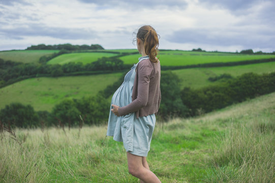Young pregnant woman standing in countryside