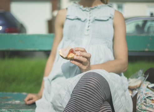 Woman eating lunch on bench
