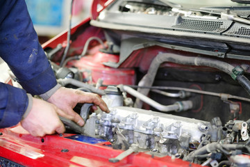 Worker repairs a car in a car repair center