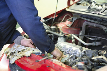 Worker repairs a car in a car repair center