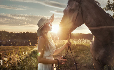 Cheerful, attractive woman with a majestic horse
