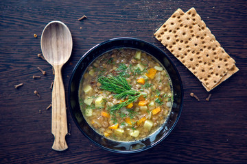 lentil soup in a black bowl on dark wooden table