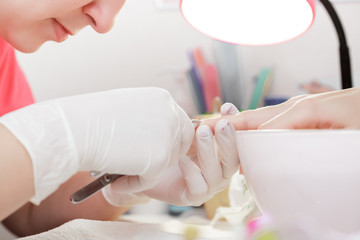 Obraz na płótnie Canvas Manicurist uses professional manicure tool.