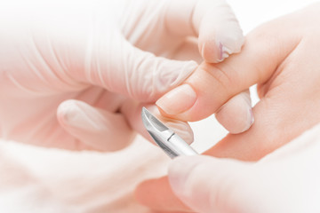 Manicurist uses  professional manicure tool.