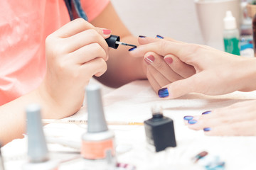 Obraz na płótnie Canvas beautician applying Polish nails to women 