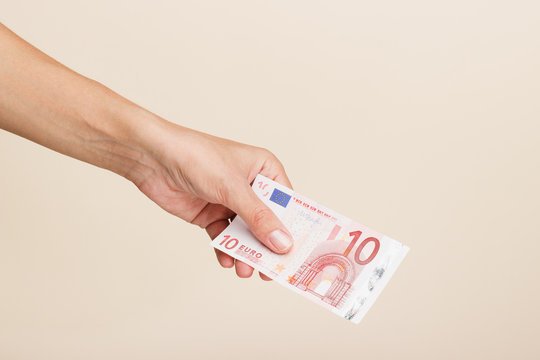 Woman's hand with money on a light background