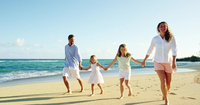 Happy family enjoying morning walk on the beach
