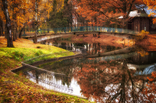 Walkway and bridge over city Park lake in autumn