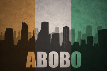 abstract silhouette of the city with text Abobo at the vintage ivorian flag