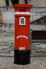 Roter freistehender runder Briefkasten mit Aufschrift Correio und Zahl 599