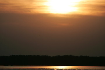 The sun sets over the lake