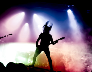 Plakat silhouette of guitar player in action on stage in front of concert crowd